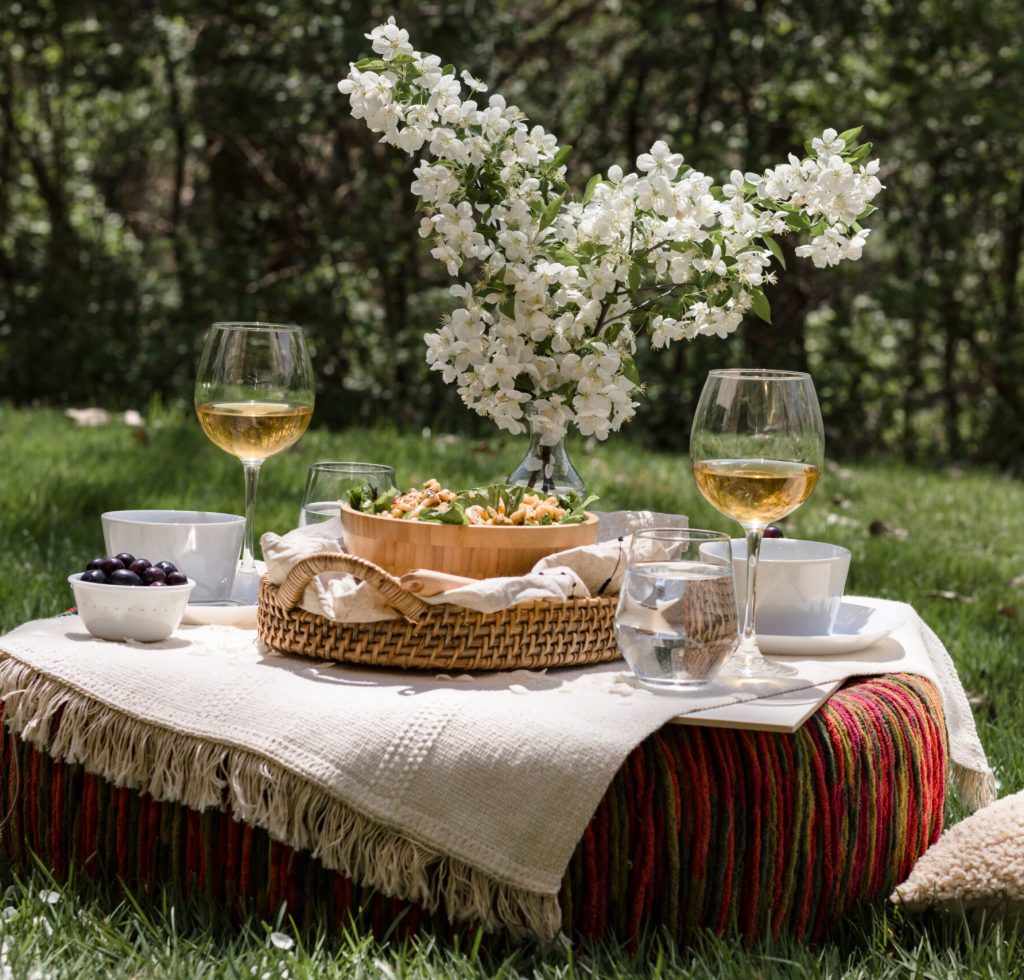 Al fresco dinning in backyard with pasta and drinks in lush green surrounding